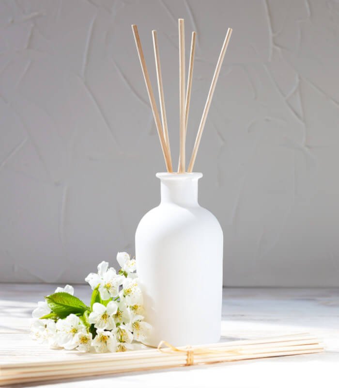 white vase filled with reed diffuser