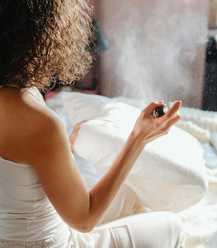 lady holds a bottle of aroma spray giving out mist