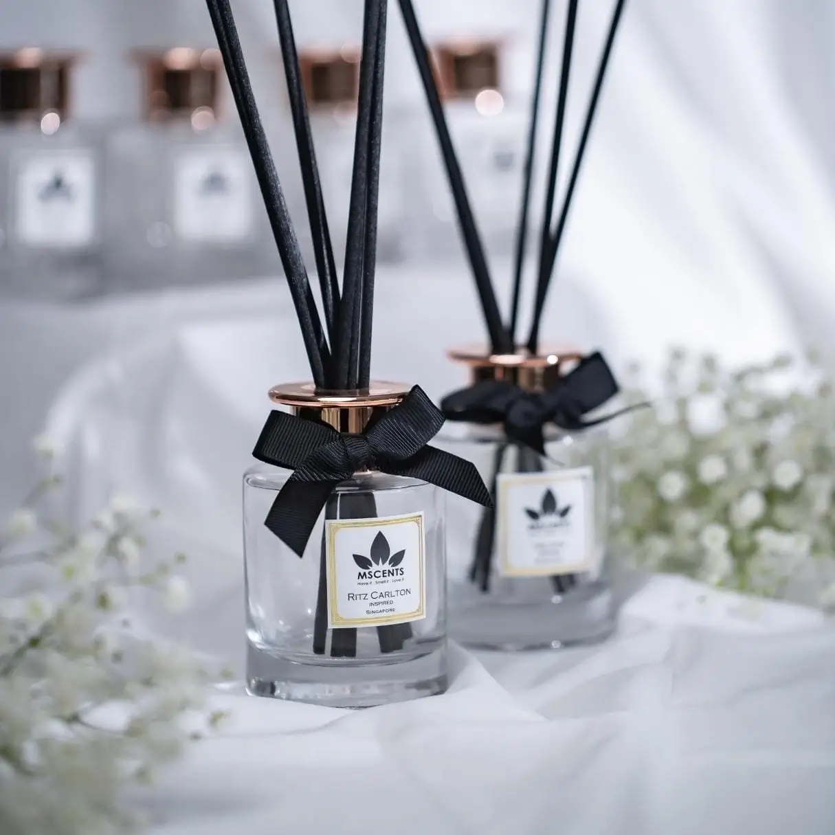 2 glass bottles of MScents hotel collection reed diffuser with black reed sticks