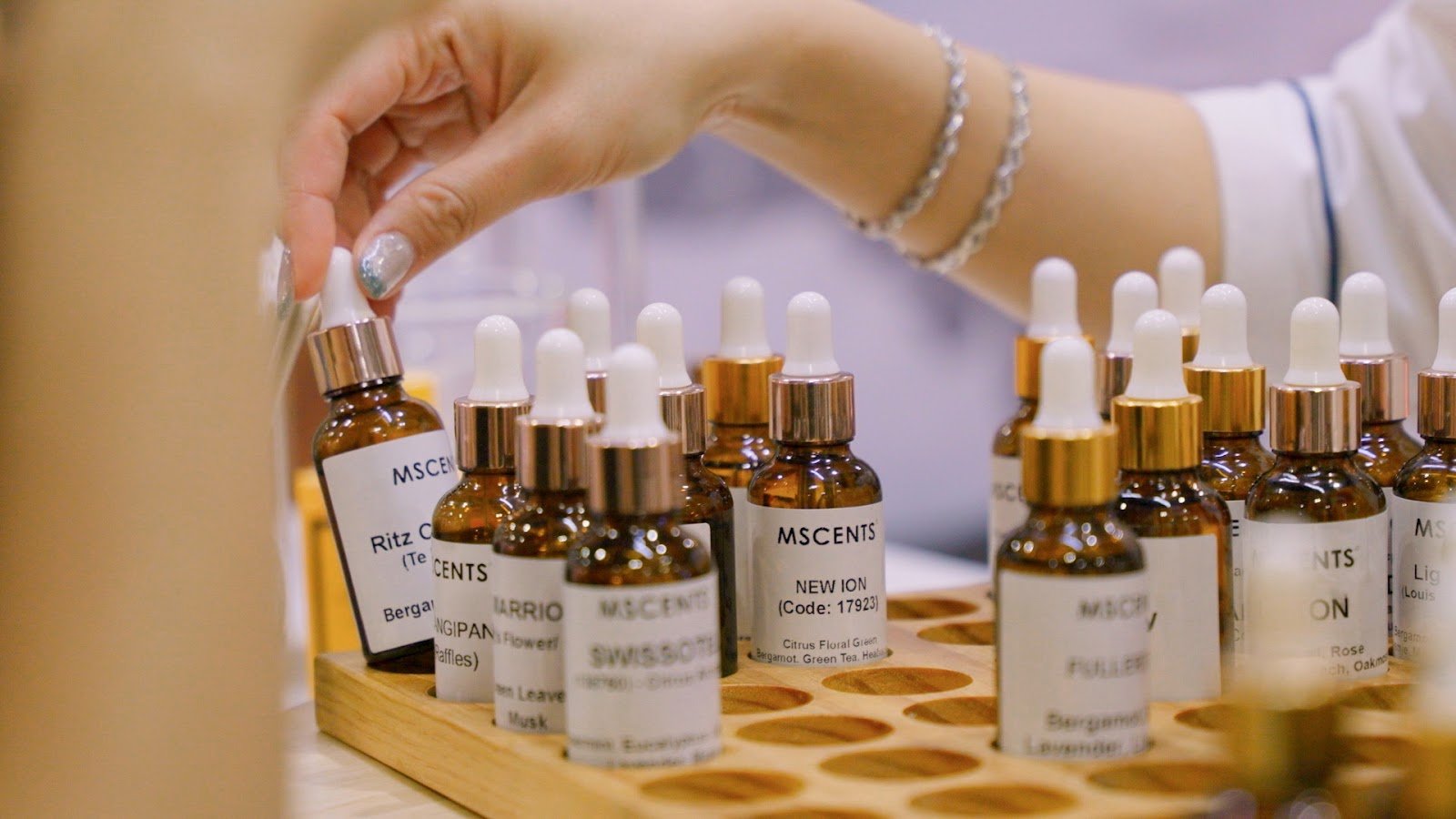 scent marketing singapore: A woman's hand handling mini scent bottles