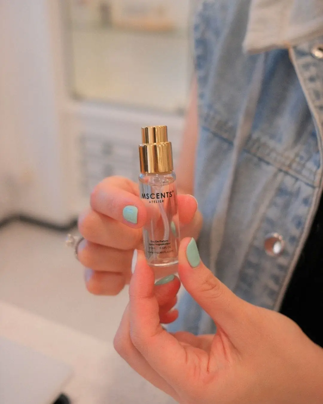 Close up of girl holding bottle of MScents eau de parfum spray