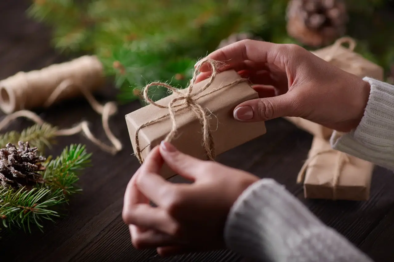 hands tying knot hemp string wrapped around gift box