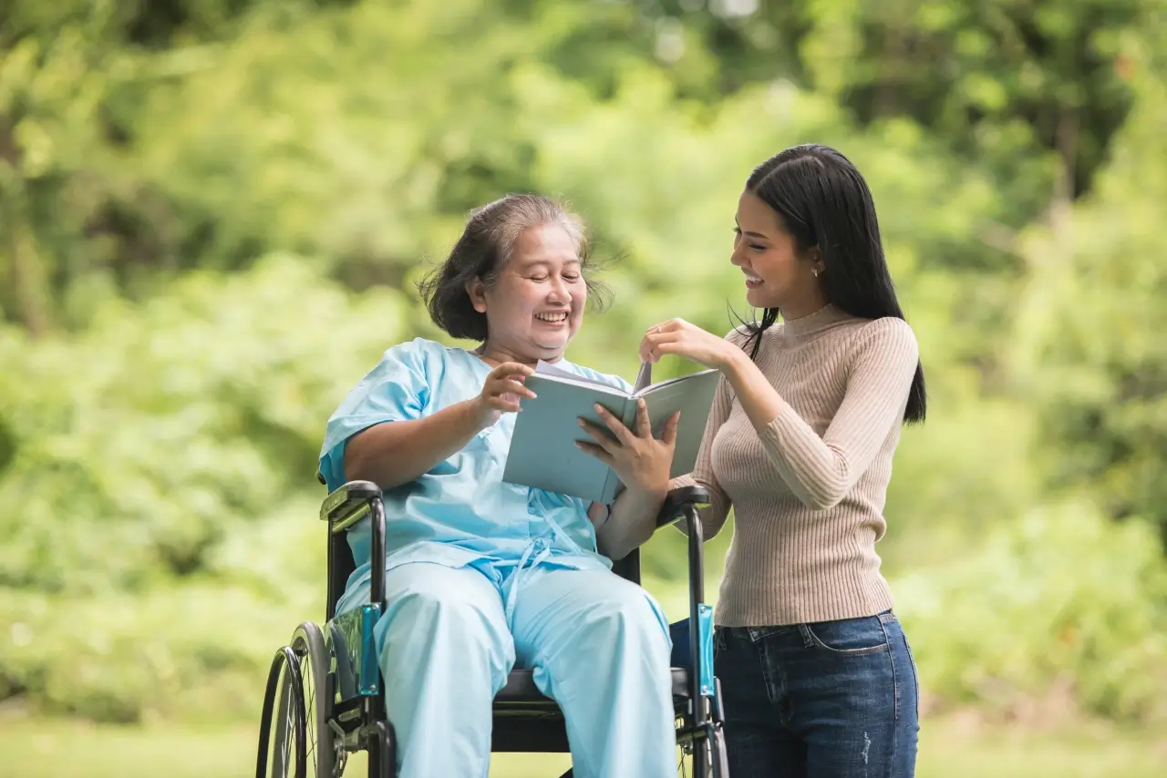 happy woman wheelchair reading book with daughter