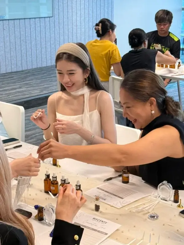 A smiling woman during a perfume-making workshop