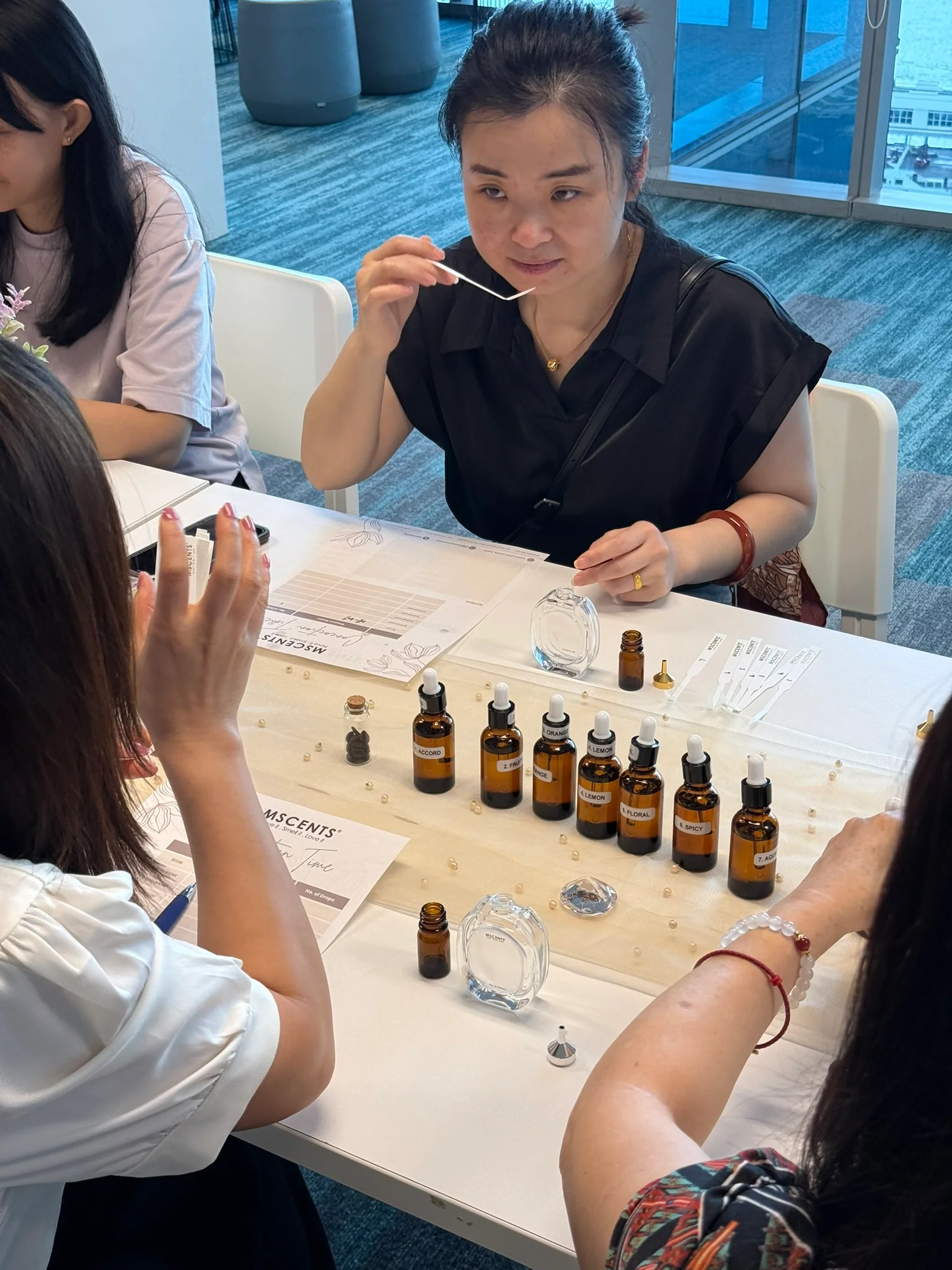 Women in a perfume-making class smelling scents