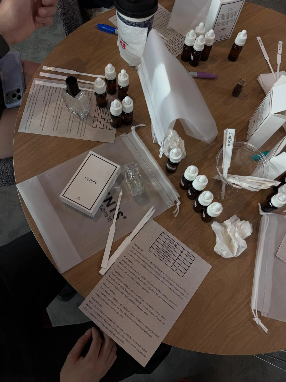 eople at an event doing a perfume-making workshop with small bottles on the table